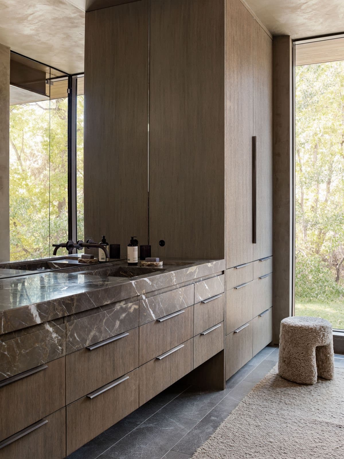 Primary bathroom with dark oak cabinetry and marble countertop
