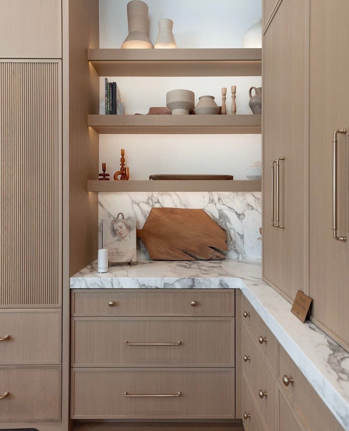 Custom cabinetry pantry with open shelving and marble countertop