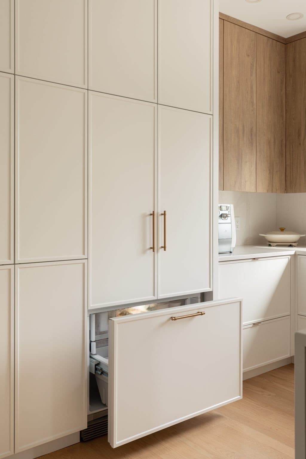 White inset cabinetry with brass hardware and wood accents